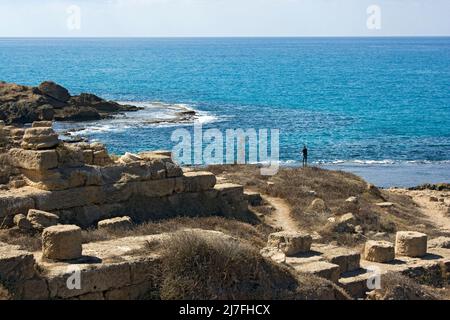 Felsformation und Fischer am Strand von Dor-Habonim, Israel Stockfoto