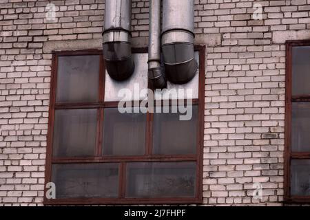 Industrielles Ziegelgebäude mit rostigen Rohren. Alte Fabrik Stockfoto