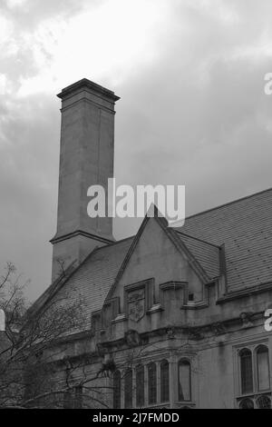 Traditionelles Kolonialgebäude mit einem Ziegelkamin in Schwarz und Weiß. Stockfoto