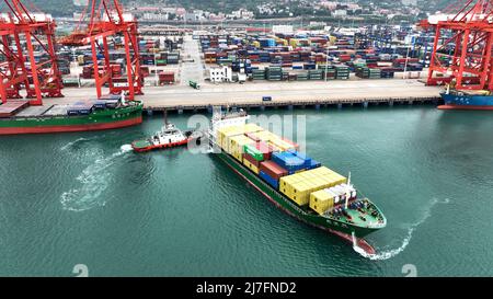 LIANYUNGANG, CHINA - 9. MAI 2022 - Ein voll beladenes Frachtschiff verlässt seinen Liegeplatz am lianyungang Port Container Terminal im ostchinesischen J Stockfoto