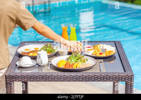 Die Kellnerin serviert Frühstück im Restaurant des Luxushotels, Resort Stockfoto