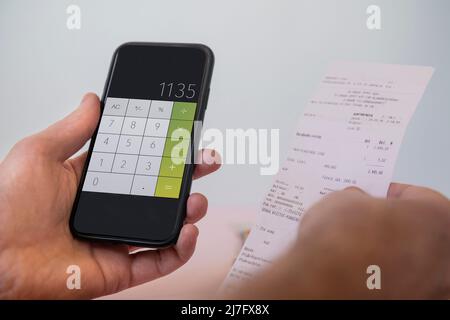 Hände halten Handy und Quittung Stockfoto
