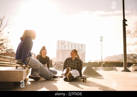 Teenager-Mädchen mit Skateboards sitzen im Skatepark Stockfoto
