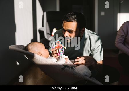 Vater und Mutter mit Baby im Wohnzimmer Stockfoto