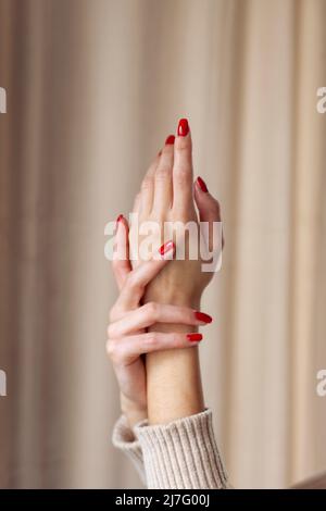 Nahaufnahme weiblicher Hände mit rotem Nagellack Stockfoto