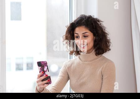 Junge Frau mit Videoanruf auf dem Smartphone Stockfoto