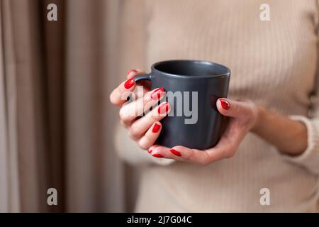 Nahaufnahme der weiblichen Hände, die den Becher halten Stockfoto