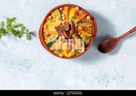 Fleisch- und Gemüsecouscous, traditionelle marokkanische Küche, von oben geschossen, mit frischen Kräutern und einem Ort für Text Stockfoto