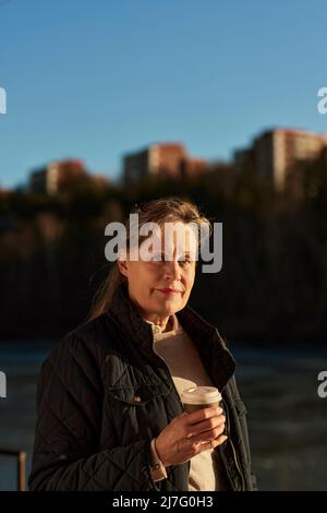 Frau mit Tasse und Kamera Stockfoto