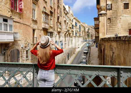 Tourist Frau hält Hut auf eiserner Brücke Blick auf die Altstadt von Valletta, Malta Stockfoto