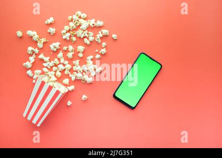 Draufsicht auf Smartphone und Popcorn auf dem Tisch Stockfoto
