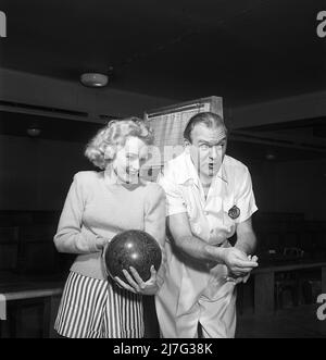 Bowling in der 1950s. Ein Mann mit der Schauspielerin UllaCarin Rydén, der zum ersten Mal den Bowlingclub besucht. Ewert Ekström zeigt im Bowling. Er war ein professioneller Bowler Spieler in der 1930s und ist zu dieser Zeit ein Lehrer und Besitzer des Bowling-Club. 1950. Schweden Kristoffersson Ref. AY36-11 Stockfoto