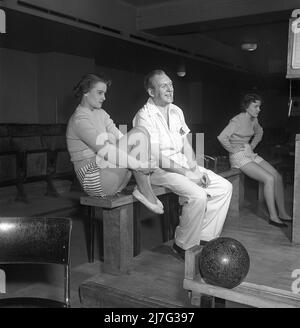 Bowling in der 1950s. Ein Mann mit drei jungen Frauen, die zum ersten Mal Bowling spielen. Die drei Mädchen sind alle Theaterschauspielerinnen: Ingrid Björk, UllaCarin Rydén und Brita Ulfberg. Ewert Ekström zeigt, dass sie beim Bowling unterrichtet werden. Er war ein professioneller Bowler Spieler in der 1930s und ist zu dieser Zeit ein Lehrer und Besitzer des Bowling-Club. 1950. Schweden Kristoffersson Ref. AY37-2 Stockfoto