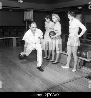 Bowling in der 1950s. Ein Mann wirft den Bowlingball und drei junge Frauen stehen daneben und schauen nach. Sie sind mit kurzen gestreiften Röcken und Pullovern bekleidet. Die drei Mädchen sind alle Theaterschauspielerinnen: Ingrid Björk, UllaCarin Rydén und Brita Ulfberg. Ewert Ekström zeigt, dass sie beim Bowling unterrichtet werden. Er war ein professioneller Bowler Spieler in der 1930s und ist zu dieser Zeit ein Lehrer und Besitzer des Bowling-Club. 1950. Schweden Kristoffersson Ref. AY36-3 Stockfoto