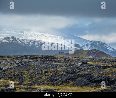 Während der Autotour in Westisland, Halbinsel Snaefellsnes, Aussichtspunkt in der Nähe des Svortuloft Leuchtturms. Spektakuläre schwarze vulkanische Felsen und schneebedecktes Snaef Stockfoto