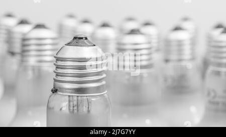 Monochrome Nahaufnahme der Glühlampenkappe aus Glas mit E27/Edison-Verschraubung. Für Beleuchtung, britische Beleuchtungsindustrie, Beleuchtung abstrakt. Stockfoto