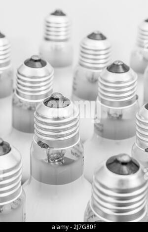 Monochrome Nahaufnahme der Glühlampenkappe aus Glas mit E27/Edison-Verschraubung. Für Beleuchtung, britische Beleuchtungsindustrie, Beleuchtung abstrakt. Stockfoto