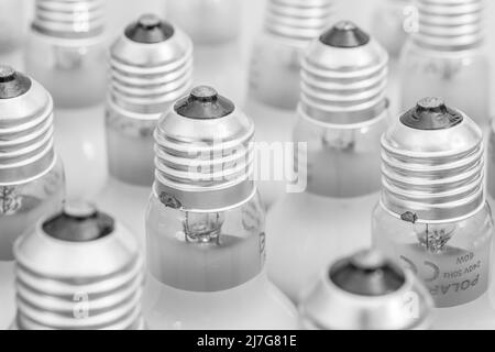 Monochrome Nahaufnahme der Glühlampenkappe aus Glas mit E27/Edison-Verschraubung. Für Beleuchtung, britische Beleuchtungsindustrie, Beleuchtung abstrakt. Stockfoto