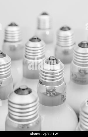 Monochrome Nahaufnahme der Glühlampenkappe aus Glas mit E27/Edison-Verschraubung. Für Beleuchtung, britische Beleuchtungsindustrie, Beleuchtung abstrakt. Stockfoto