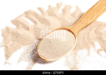 Aktive Trockenbackhefe-Granulat in Holzlöffel. Stockfoto