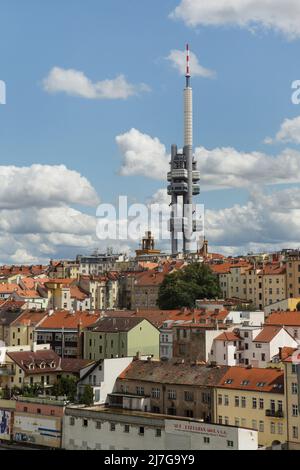 Der Fernsehturm Žižkov (Žižkovský vysílač), der über den Dächern im Stadtteil Žižkov in Prag, Tschechische Republik, aufgestellt wurde. Zwischen 1985 und 1992 wurde der Fernsehturm von Žižkov, entworfen vom Architekten des tschechischen Modernismus Václav Aulický, errichtet. 2000 wurden zehn Skulpturen namens 'Miminka' ('Babies'), die vom tschechischen bildenden Künstler David Černý entworfen wurden, vorübergehend an den Turm angebaut. Stockfoto