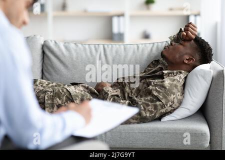 Verärgert schwarzen Kerl Soldat lag auf der Couch während Therapie-Sitzung Stockfoto