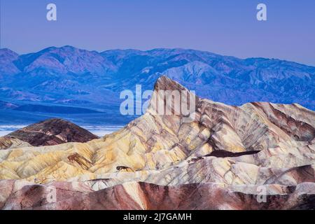 Morgendämmerung am Zabriskie Point, Death Valley National Park, Kalifornien. Die bunten Formationen von Manly Beacon mit den Badlands und Bergen in der Dista Stockfoto