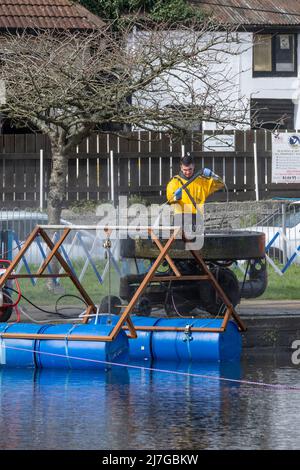 Ein Arbeiter, der einen Hochdruckreiniger verwendet und Wartungsarbeiten an einem Brunnen am Trenance Boating Lake in Newquay in Cornwall in Großbritannien durchführt. Stockfoto