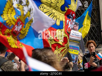 München, Deutschland. 09.. Mai 2022. Demonstranten (r) mit einer Puppe mit einem Bild des russischen Präsidenten Putin und der Aufschrift "Putin in Den Haag - Putin vor Gericht" protestieren auf dem Odeonsplatz gegen eine prorussische Demonstration (l), deren Teilnehmer in russischen Farben Flaggen schwingen, um des "Siegestages" am Ende des Zweiten Weltkriegs zu gedenken Der Internationale Gerichtshof, der Kriegsverbrechen verfolgt, hat seinen Sitz in Den Haag, Niederlande. Kredit: Peter Kneffel/dpa/Alamy Live Nachrichten Stockfoto