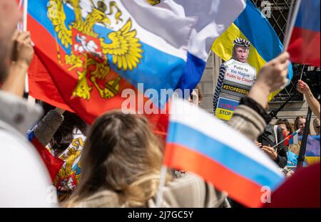 München, Deutschland. 09.. Mai 2022. Demonstranten (r) mit einer Puppe mit einem Bild des russischen Präsidenten Putin und der Aufschrift "Putin in Den Haag - Putin vor Gericht" protestieren auf dem Odeonsplatz gegen eine prorussische Demonstration (l), deren Teilnehmer in russischen Farben Flaggen schwingen, um des "Siegestages" am Ende des Zweiten Weltkriegs zu gedenken Der Internationale Gerichtshof, der Kriegsverbrechen verfolgt, hat seinen Sitz in Den Haag, Niederlande. Kredit: Peter Kneffel/dpa/Alamy Live Nachrichten Stockfoto