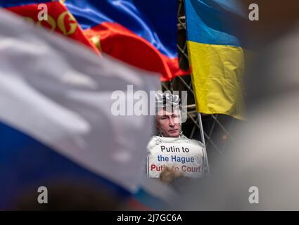 München, Deutschland. 09.. Mai 2022. Demonstranten (r) mit einer Puppe mit einem Bild des russischen Präsidenten Putin und der Aufschrift "Putin in Den Haag - Putin vor Gericht" protestieren auf dem Odeonsplatz gegen eine prorussische Demonstration (l), deren Teilnehmer in russischen Farben Flaggen schwingen, um des "Siegestages" am Ende des Zweiten Weltkriegs zu gedenken Der Internationale Gerichtshof, der Kriegsverbrechen verfolgt, hat seinen Sitz in Den Haag, Niederlande. Kredit: Peter Kneffel/dpa/Alamy Live Nachrichten Stockfoto