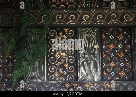 Farnblatt und dekoratives Gemälde in traditionellem Motiv an der Wand einer Reisscheune im Dorf Kete Kesu, Nord-Toraja, Süd-Sulawesi, Indonesien. Stockfoto