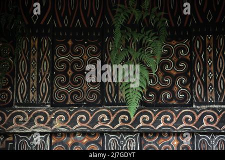 Farnblatt und dekoratives Gemälde in traditionellem Motiv an der Wand einer Reisscheune im Dorf Kete Kesu, Nord-Toraja, Süd-Sulawesi, Indonesien. Stockfoto