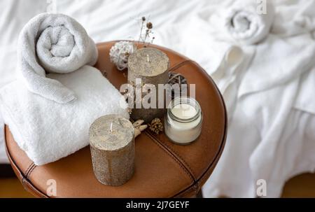 Spa-Komposition mit Kerzen und Handtüchern auf unscharfem Hintergrund. Stockfoto
