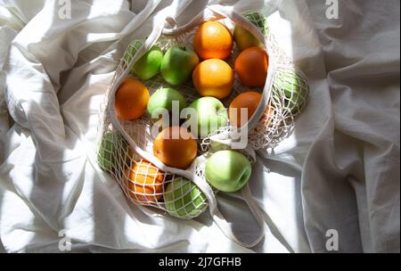 Saitenbeutel mit Früchten im Bett mit Sonnenstrahlen. Stockfoto
