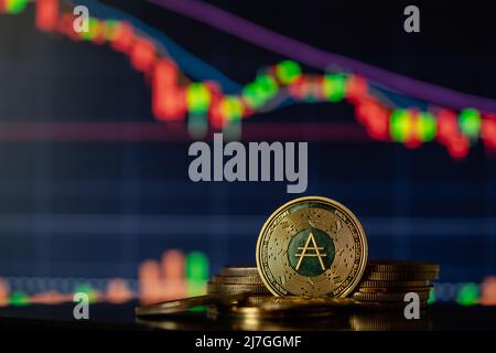 Stapel oder Haufen von Gold Cardano ADA Kryptowährung mit Candle-Stick-Diagramm und digitalen Hintergrund. Stockfoto