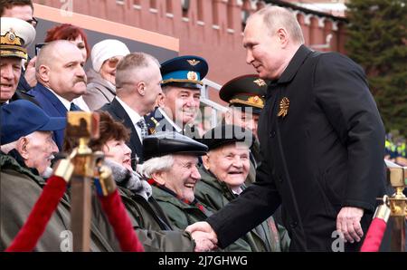 Moskau, Russland. 09.. Mai 2022. Der russische Präsident Wladimir Putin schüttelt sich die Hände mit Veteranen zu Beginn der jährlichen Militärparade zum Victory Day 77., die am 9. Mai 2022 in Moskau, Russland, das Ende des Zweiten Weltkriegs auf dem Roten Platz feiert. Quelle: Mikhail Metzel/Kremlin Pool/Alamy Live News Stockfoto