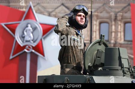 Moskau, Russland. 09.. Mai 2022. Ein russischer Soldat begrüßt, als er den Überprüfungsstand während der jährlichen Militärparade zum Victory Day 77. passiert, die am 9. Mai 2022 in Moskau, Russland, das Ende des Zweiten Weltkriegs auf dem Roten Platz feiert. Quelle: Mikhail Metzel/Kremlin Pool/Alamy Live News Stockfoto