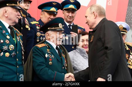 Moskau, Russland. 09.. Mai 2022. Der russische Präsident Wladimir Putin schüttelt sich die Hände mit Veteranen zu Beginn der jährlichen Militärparade zum Victory Day 77., die am 9. Mai 2022 in Moskau, Russland, das Ende des Zweiten Weltkriegs auf dem Roten Platz feiert. Quelle: Mikhail Metzel/Kremlin Pool/Alamy Live News Stockfoto