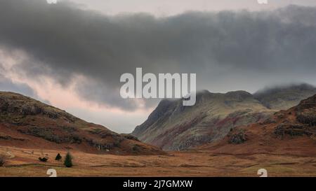 Epische Landschaft mit Sonnenaufgangslicht über Blea Tarn im Lake District mit atemberaubendem Licht auf fernen Bergen Stockfoto