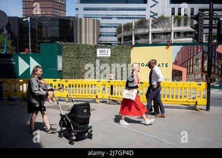 Londoners gehen am 6.. Mai 2022 in London, England, durch eine Industrielandschaft des Bauunternehmers Robert McAlpine von „One Broadgate“, einer Sanierung von 1 Broadgate in der Nähe der Liverpool Street Station in der City of London, dem Finanzdistrikt der Hauptstadt. Stockfoto