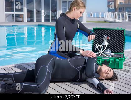 Scuba Diving Rettungskurs Fähigkeiten Patient in Erholungsposition wartet auf Hilfe zu kommen Stockfoto