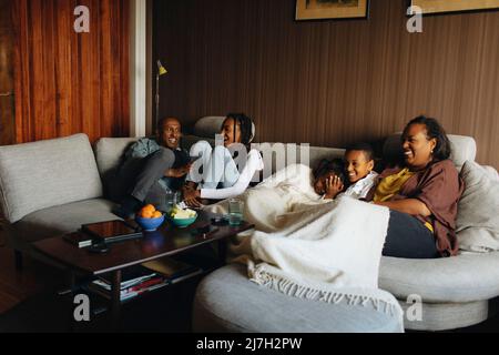 Glückliche Familie sitzt zusammen auf dem Sofa im Wohnzimmer zu Hause Stockfoto