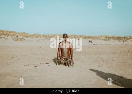 Mann aus Gusseisen von Antony Gormley im Sand am Crosby Beach, England Stockfoto