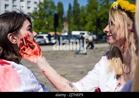 Aktivisten, die mit roter Farbe die zivilen Opfer des Krieges symbolisieren, sind auf dem Protest zu sehen. Hunderte von Ukrainern und polnischen Aktivisten protestierten auf einem Warschauer Friedhof vor Soldaten der Roten Armee, die während des Zweiten Weltkriegs starben Der russische Botschafter in Polen, Sergej Andreev, wurde von Demonstranten, die gegen den Krieg in der Ukraine waren, bei einer jährlichen Veranstaltung zum Tag des Sieges zum Gedenken an das Ende des Zweiten Weltkriegs mit roter Farbe angestrichen Botschafter Sergej Andreew kam am Tag des Sieges auf dem sowjetischen Soldatenfriedhof an, um Blumen zu legen, aber der Diplomat und seine Delegation waren gezwungen, das Gebiet in Begleitung der Polizei zu verlassen Stockfoto