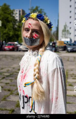 Aktivist mit roter Farbe gemalt, die die zivilen Opfer des Krieges symbolisiert, die während des Protestes gesehen wurden. Hunderte von Ukrainern und polnischen Aktivisten protestierten auf einem Warschauer Friedhof vor Soldaten der Roten Armee, die während des Zweiten Weltkriegs starben Der russische Botschafter in Polen, Sergej Andreev, wurde von Demonstranten, die gegen den Krieg in der Ukraine waren, bei einer jährlichen Veranstaltung zum Tag des Sieges zum Gedenken an das Ende des Zweiten Weltkriegs mit roter Farbe angestrichen Botschafter Sergej Andreew kam am Tag des Sieges auf dem sowjetischen Soldatenfriedhof an, um Blumen zu legen, aber der Diplomat und seine Delegation waren gezwungen, das Gebiet in Begleitung der Polizei zu verlassen Stockfoto