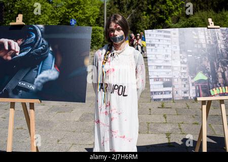 Ein Protestler mit mit Klebeband versiegelten Lippen nimmt an dem Protest Teil. Hunderte von Ukrainern und polnischen Aktivisten protestierten auf einem Warschauer Friedhof vor Soldaten der Roten Armee, die während des Zweiten Weltkriegs starben Der russische Botschafter in Polen, Sergej Andreev, wurde von Demonstranten, die gegen den Krieg in der Ukraine waren, bei einer jährlichen Veranstaltung zum Tag des Sieges zum Gedenken an das Ende des Zweiten Weltkriegs mit roter Farbe angestrichen Botschafter Sergej Andreew kam am Tag des Sieges auf dem sowjetischen Soldatenfriedhof an, um Blumen zu legen, aber der Diplomat und seine Delegation waren gezwungen, das Gebiet in Begleitung von Polizisten zu verlassen. (Foto von Attila Husejno Stockfoto