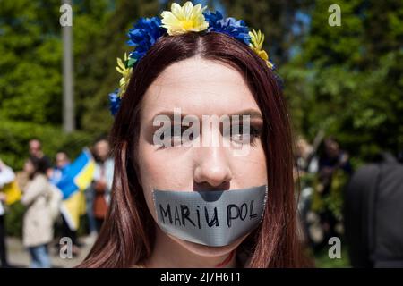 Ein Protestler mit mit Klebeband versiegelten Lippen nimmt an dem Protest Teil. Hunderte von Ukrainern und polnischen Aktivisten protestierten auf einem Warschauer Friedhof vor Soldaten der Roten Armee, die während des Zweiten Weltkriegs starben Der russische Botschafter in Polen, Sergej Andreev, wurde von Demonstranten, die gegen den Krieg in der Ukraine waren, bei einer jährlichen Veranstaltung zum Tag des Sieges zum Gedenken an das Ende des Zweiten Weltkriegs mit roter Farbe angestrichen Botschafter Sergej Andreew kam am Tag des Sieges auf dem sowjetischen Soldatenfriedhof an, um Blumen zu legen, aber der Diplomat und seine Delegation waren gezwungen, das Gebiet in Begleitung von Polizisten zu verlassen. (Foto von Attila Husejno Stockfoto