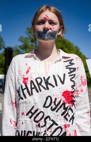 Warschau, Polen. 09.. Mai 2022. Aktivist mit roter Farbe gemalt, die die zivilen Opfer des Krieges symbolisiert, die während des Protestes gesehen wurden. Hunderte von Ukrainern und polnischen Aktivisten protestierten auf einem Warschauer Friedhof vor Soldaten der Roten Armee, die während des Zweiten Weltkriegs starben Der russische Botschafter in Polen, Sergej Andreev, wurde von Demonstranten, die gegen den Krieg in der Ukraine waren, bei einer jährlichen Veranstaltung zum Tag des Sieges zum Gedenken an das Ende des Zweiten Weltkriegs mit roter Farbe angestrichen Botschafter Sergej Andreew kam am Tag des Sieges auf dem sowjetischen Soldatenfriedhof an, um Blumen zu legen, aber der Diplomat und seine Delegation waren gezwungen, den zu verlassen Stockfoto