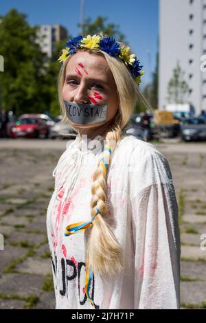 Warschau, Polen. 09.. Mai 2022. Aktivist mit roter Farbe gemalt, die die zivilen Opfer des Krieges symbolisiert, die während des Protestes gesehen wurden. Hunderte von Ukrainern und polnischen Aktivisten protestierten auf einem Warschauer Friedhof vor Soldaten der Roten Armee, die während des Zweiten Weltkriegs starben Der russische Botschafter in Polen, Sergej Andreev, wurde von Demonstranten, die gegen den Krieg in der Ukraine waren, bei einer jährlichen Veranstaltung zum Tag des Sieges zum Gedenken an das Ende des Zweiten Weltkriegs mit roter Farbe angestrichen Botschafter Sergej Andreew kam am Tag des Sieges auf dem sowjetischen Soldatenfriedhof an, um Blumen zu legen, aber der Diplomat und seine Delegation waren gezwungen, den zu verlassen Stockfoto